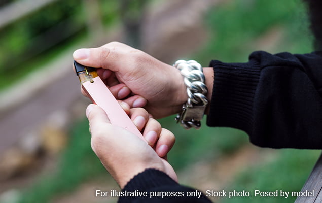 Hands holding leaking vape